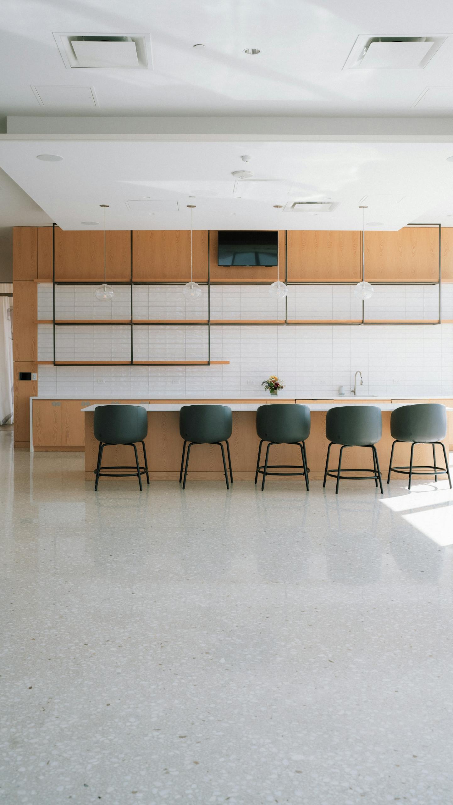 Sleek and modern kitchen space featuring a minimalist design with bar seating and clean lines.