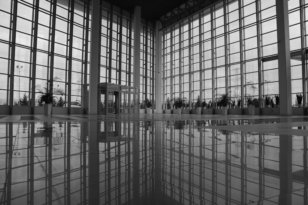 Spacious modern atrium with glass walls and polished reflections, exuding an urban architectural style.